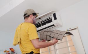 Kỹ thuật viên đang vệ sinh lưới lọc của hệ thống điều hòa, với các dụng cụ chuyên dụng. Hình ảnh cho thấy sự chăm sóc cẩn thận nhằm đảm bảo hiệu suất hoạt động và tiết kiệm năng lượng