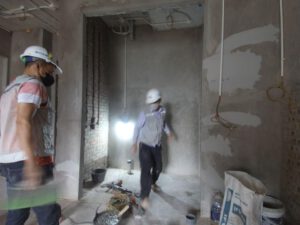 Một công nhân đang kiểm tra và thi công chống thấm cho tường hoặc nền móng của tòa nhà, sử dụng các vật liệu chống thấm hiện đại như màng polyurethane. Hình ảnh minh họa quy trình chống thấm chuyên nghiệp giúp bảo vệ tòa nhà lâu dài.