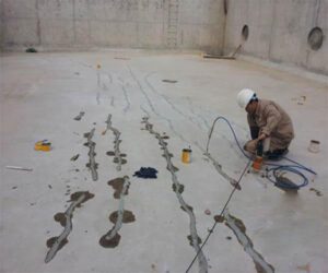 Ảnh thi công keo chống thấm PU: Công nhân đang bơm keo chống thấm PU vào các vết nứt trên bề mặt bể nước.