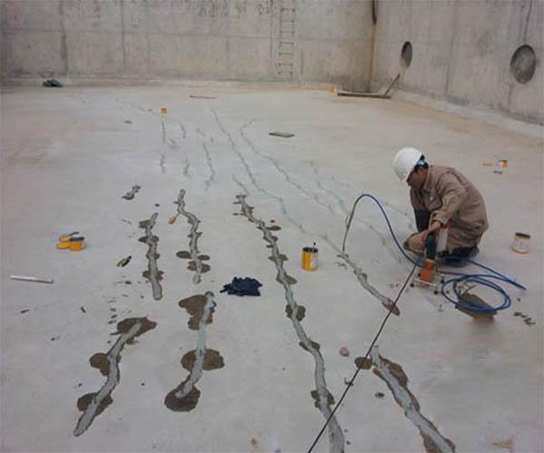 Ảnh thi công keo chống thấm PU: Công nhân đang bơm keo chống thấm PU vào các vết nứt trên bề mặt bể nước.